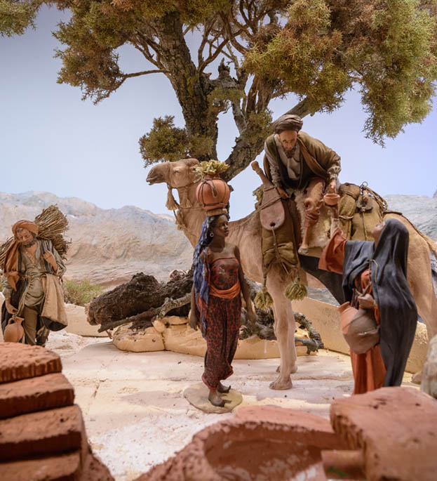 Mujer dando agua a hombre en camello