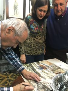 Josep Traité, firmando una obra, junto a Ana Caballero y Antonio Díaz